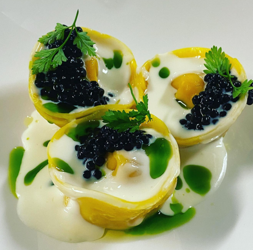 Tortello doppio tuorlo, zucca , mostarda di cipolle, salsa al trentin grana stagionato, perlage di tartufo nero, erbe spontanee, cerfoglio